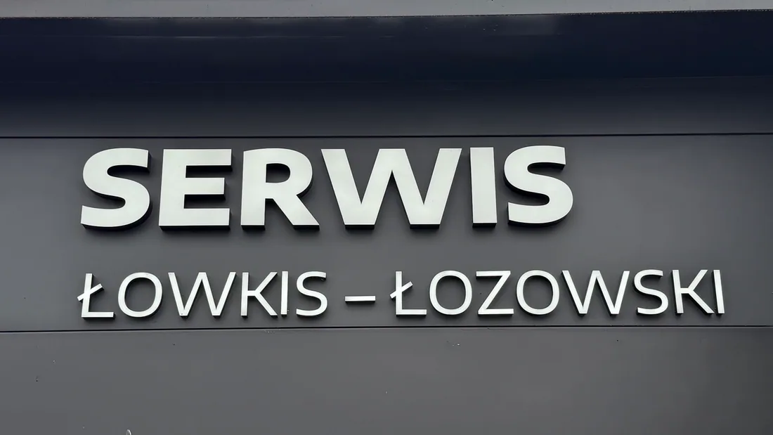 Zbliżenie na czytelny szyld Serwis Łowkis-Łozowski